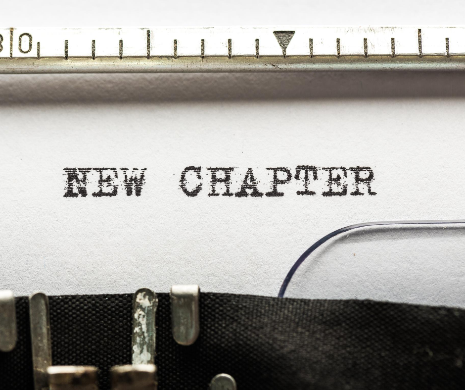 Piece of paper in a typewriter with the text NEW CHAPTER.