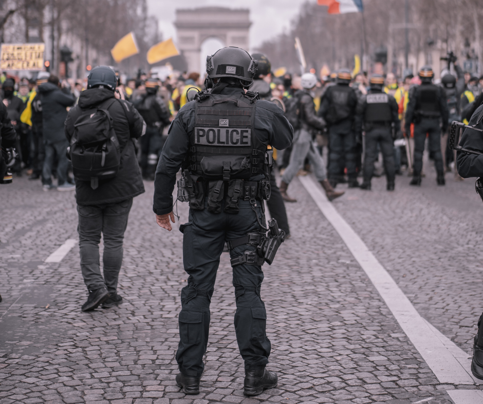 Several police lined up against a group of protestors.